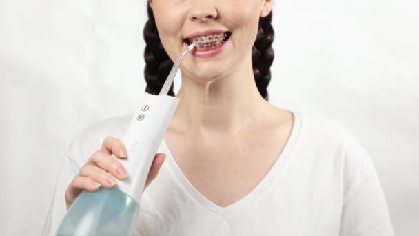 Zbliżenie Młodej Uśmiechniętej Kobiety Wspornikami Zębach Pokazuje Jak Czyści Pomocą — Wideo stockowe