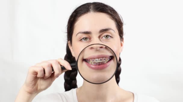 Close Mulher Segurando Lupa Mostrando Dentes Com Zoom Com Aparelho — Vídeo de Stock