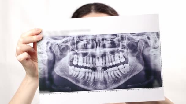 若い白人微笑む女性の肖像画は 拡大鏡ガラス および靭帯のブレースで歯を示しています ホワイトバック 矯正治療の概念について — ストック動画