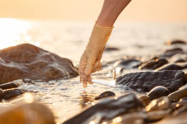 Kauçuk eldiven giyip kapağı kapatın. Denizden alınan su numune şişesi alın. Geri dönüşüm suyu kaynakları ve bilim testi kavramı.