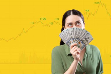 Borsa ve ticaret. Bir kadının portresi, bir dolar para fanatiğiyle yüzünü kapatıp yukarı bakıyor. Uzayı kopyala İş ve yatırım kavramı.
