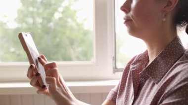 Kadın baskısının yan görüntüsü parmaklarını hızlı bir şekilde akıllı telefon ekranında sanal şifreli paralar kazanıyor. Çevrimiçi para kazanmak için kayıt. Şifreli uygulama ve çiftçilik. Arkaplandaki pencere