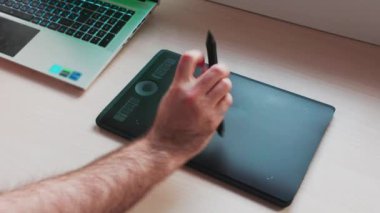 Dijital illüstrasyonun yaratılması. Adam Stylus 'u tablet çizmekten alıyor ve çizmeye başlıyor. Elle yakından çek. Rötuş kavramı