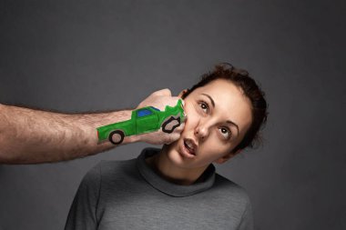 the concept of car accidents, insurance claims . A woman is punched in the face . on fist drawn car. clipart