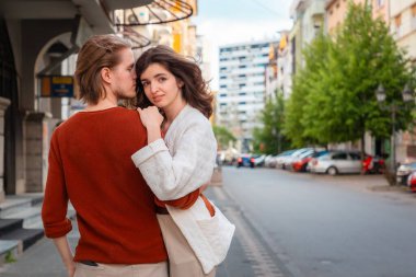 Sokakta kucaklaşan genç, beyaz, romantik bir çiftin arka planı, randevu ayarlamak. Sevgililer Günü. Uzayı kopyala İlişki psikolojisi kavramı.