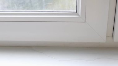  Su sızdıran bir pencere çerçevesi, pencere pervazında su birikintisi. Pencerelerle ilgili sorun
