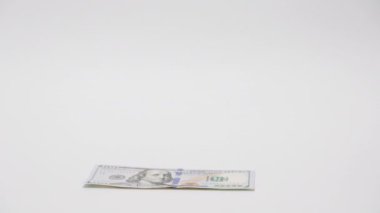 Yatırımlar ve mevduatlar. Kadın Amerikan dolarlarını sayıyor ve erkek banknotların üstüne küçük domuzcuk kumbarası koyuyor. Yakın plan çekimleri ve para beyaz arka planda. Tasarruf kavramı.