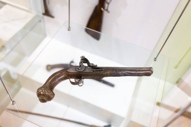 Karmaşık ahşap desenli dekore edilmiş antika silah manzarası. Müzede sergilenen eski bir 19. yüzyıl tabancası..