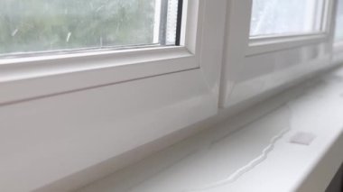 Pencerenin kenarına su sızdıran bir çerçeve, pencere kenarında bir su birikintisi. Yağmurlu hava
