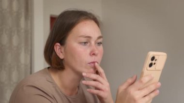 Kafkasyalı genç bir kadının portresi akıllı telefon kullanıyor ve şaşkınlık ve şok hissi yaşıyor. Psikoloji kavramı.