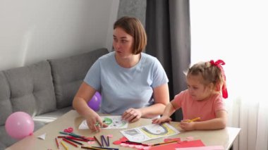 Yetişkin anne ve kızının en iyi görüntüsü Sevgililer Günü için anneler günü kartlarını birlikte süslüyor. Çocuklar için okul öncesi eğitim.