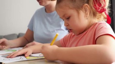 Beyaz kız ve kadın sevgililer günü için anneler günü kartlarını birlikte süslüyorlar. Çocuklar için okul öncesi eğitim.