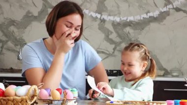 Paskalya Bahar Festivali. Mutlu anne ve komik kızın orta fotoğrafı birlikte çocuk yaratıcılığıyla meşgul, Paskalya süslemeleri yapıyorlar..