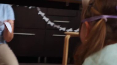 Ev yapımı tavşan maskeli mutlu küçük bir kız ve anne Paskalya oyunu oynuyor masanın altında. Bahar tatili kavramı.