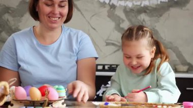 Paskalya bahar tatili. Mutlu beyaz anne portresi ve gülümseyen küçük tatlı kız birlikte çocuk yaratıcılığı yapıyorlar, Paskalya süslemeleri yapıyorlar..