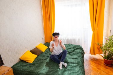 İnanılmaz bir kadın VR kulaklık kullanarak fotorealistik dijital alanlarla etkileşime giriyor, büyüleyici hikaye anlatımlarını keşfediyor. Üst görünüm.