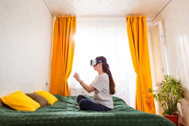 Kafkasyalı genç bir kadının gelecek nesil bir sanal gerçeklik deneyimi yaşamasının yan görüntüsü, geleceğe hazır oyunlarla bağlantı kuruyor. Geniş açı.