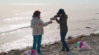 Aktivistler okyanusu temizlemeye ve çevresel sorumluluklar hakkında farkındalığı artırmaya yardım ediyorlar. Sürdürülebilir yaşam ve kirlilik kontrolü kavramı. Kadınlar bir fren yapar ve çay içer..