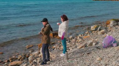 Çevre eylemcileri kirliliği azaltmak ve vahşi yaşamı korumak için sahil şeridinden plastik ve diğer atıkları topluyorlar. Gönüllüler bir fren yapıp çay içsin. Yan geniş görünüm.