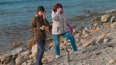 Gönüllüler sahilin güzelliğini geri getirmek için sahilden plastik atık topluyor. Gönüllüler bir fren yapıp çay içsin. Uzun menzilli çekim. İnsanlar çevreyi kurtarmak için harekete geçiyor.