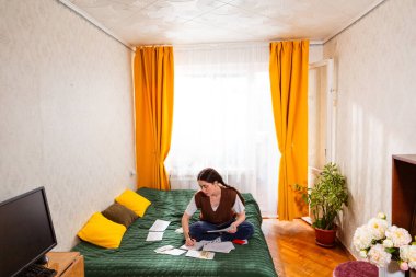 Yatırım planlaması için tasarruf ve mali hedefler hesaplayan bir kadın. Finansal okur yazarlık ve ekonomik sorumluluk kavramı. Geniş açı, üst görünüm.