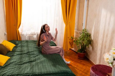 Rahatlamış genç bir kadın anı müzikle ve şarkıyla kucaklıyor. Geniş açı.