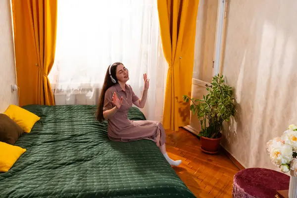 Rahatlamış genç bir kadın anı müzikle ve şarkıyla kucaklıyor. Geniş açı.