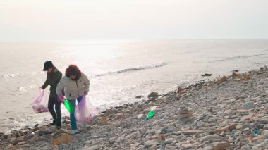  Çevreciler kirliliği durdurmak ve sürdürülebilirliği desteklemek için vahşi bir sahilden çöp çıkarıyorlar. İnsanlar okyanusu korumak ve plastik atıkları azaltmak için temizlik girişiminde bulunuyor. Geniş açı