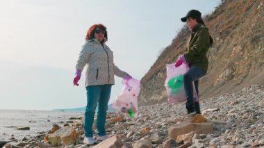 Gönüllüler kıyı boyunca plastik atık toplayıp okyanus kirliliğini durduruyor ve koruma konusundaki farkındalığı artırıyorlar. İnsanlar gezegeni ve deniz biyolojik çeşitliliğini korumak için birlikte çalışıyorlar..