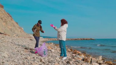 İki kadın sahilden enkaz toplayarak kirliliği azaltıyor ve çevresel sorumluluğun önemi hakkında farkındalığı artırıyor. İnsanlar doğa ve deniz yaban hayatını korumak için harekete geçiyor..