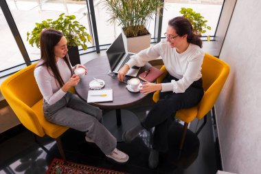 Kahve masasında içerik fikirlerini paylaşan iki beyaz girişimci. Strateji, markalaşma ve yenilik kavramı. Üst görünüm.