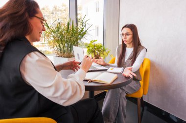 Öğle yemeği sırasında şık bir şehir kafesinde yaratıcı beyinler iş başında. Pazarlama liderliği ve kadın yetkilendirmesi kavramı. Orta çekim.