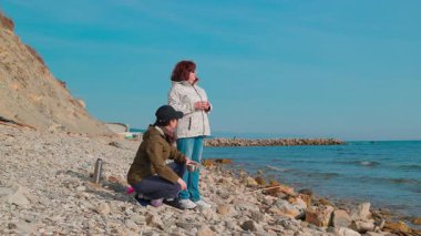 İki kadın uzak bir plajdan çöp topluyor, plastik atıkları azaltıyor ve sorumlu atık kullanımını teşvik ediyor. Gönüllüler bir fren yapıp çay içsin. Tam boy çekim