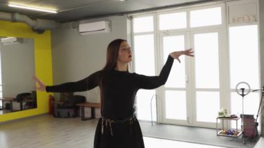 Slim active Kafkasyalı kız profesyonel fitness stüdyosunda ritmik dans gösterisi yapıyor. Koreografili eğitim kalitesinin ve pozitif enerjinin özünü yakalıyor. Orta çekim.