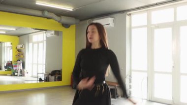 Fit beyaz kadın dansçı, sağlıklı fiziksel aktivite ve spor temelli yaşam tarzı ilhamı kavramını temsil eden geniş beden eğitimi iç mimarisinde etkileyici koreografiyi prova ediyor. Orta çekim.