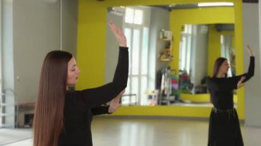 Atletik genç beyaz kadın modern spor salonunda spor yaparken dinamik dans hareketleri yapıyor. Sağlıklı yaşam tarzını destekliyor ve esneklik ve koordinasyon için aktif egzersiz yapıyor. Arka plan.