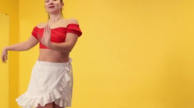 Sportif bir kadın spor salonunda tutkulu bir şekilde dans ediyor. Kuvveti, esnekliği, sanatsal özgürlüğü ve istikrarlı atletik gelişimi kucaklıyor. Orta çekim, bachata dansı..