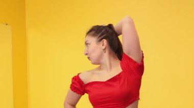 Kafkas kökenli genç bir kadın, spor salonunun atletik ortamında kendini ifade etme ve enerji artırma alışkanlıklarını destekleyen dans becerileri gösteriyor. Orta çekim.