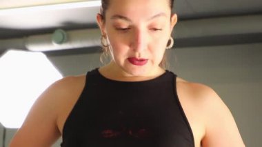 Disiplinli bir esmer, statik bir esnemede mükemmel bir duruş sergiler. Onun rutini esneklik, istikrar ve vücut farkındalığı oluşturur. Orta çekim.