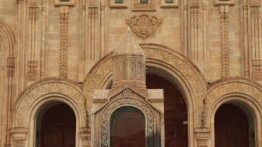 Mavi gökyüzünün altında parlayan haçı ve kubbesi ile Tiflis 'in görkemli Kutsal Üçlü Katedrali derin Hıristiyan inancını, ruhani geleneği ve Gürcistan Ortodoksluğunu yansıtıyor. Jib çekimi.