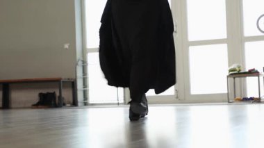 Siyahlı kadın dansçı Lezginka 'nın cesur adımlarını rehberlik ederek gerçekleştiriyor. Kültürel gurur, spor eğitimi ve dışavurumcu hareket kavramı. Ayaklarını kapat..