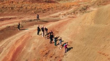 19.10.2024, Tiflis, Georgia. Bir grup çok ırklı turist açık hava macera turu sırasında çöl tepelerinde birlikte yürüyüş yaparak doğayı keşfediyor, aşırı seyahatlerin ve modern sırt çantalı yaşam tarzının tadını çıkarıyor..