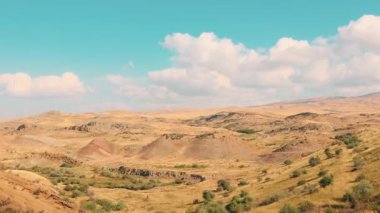 Bakır renkli kil tepeler ve Gürcistan 'da canlı mavi gökyüzü altında kuru savana manzarası vahşi doğanın ve macera yolculuğunun esansını yakalıyor. Geniş açı.