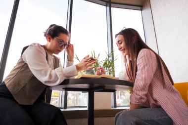 Marka mimarisi inşa eden ve dijital iş yönlerini planlayan iki beyaz kadın arasındaki stratejik diyalog. Alt görünüm.