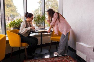 İki zeki beyaz kadın bir kafede stratejik bir öğle yemeği sırasında dijital geleceklerini tartışıyor ve yaratıcı iş içeriğini planlıyorlar. Orta çekim.