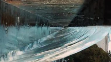 Belediye binasının yakınındaki çeşme çağlayanı manzarası. Sıcak bir yaz gününde serin su akıntıları şehir havasını tazeler. Su jetine bak. Dikey.