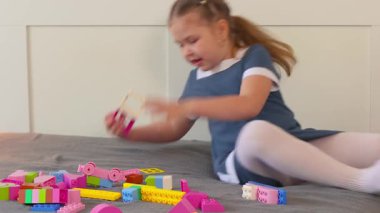 Genç beyaz kız parlak bir alanda bloklarla oynarken şekilleri ve dengeyi keşfediyor. Anaokulu eğitimi kavramı