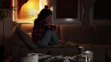 Psikolojik sorun ve panik. Yalnız beyaz bir kadın kanepede oturuyor ve sallanıyor. İyi akşamlar. Obsesif kompulsif bozukluk ve depresyon.