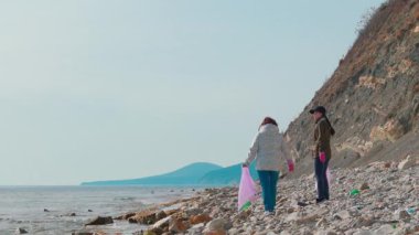 Eylemciler, kirliliği önlemek ve vahşi yaşamı korumak için uzak bir kıyı şeridini plastik atıkları ve diğer çöpleri temizleyerek temizliyorlar. İnsanlar doğayı yeniden canlandırmak ve okyanus kirliliğiyle savaşmak için harekete geçerler..