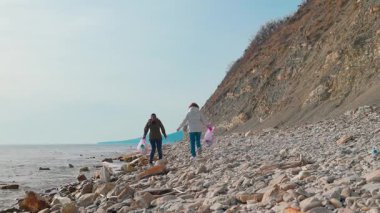 İki gönüllü, çevresel bir felaketi önlemek ve kirlilik kontrolü hakkındaki farkındalığı artırmak için plajdan çöp çıkartıyor. İnsanlar okyanusu temizlemek ve doğayı korumak için harekete geçiyor. Geniş açı.